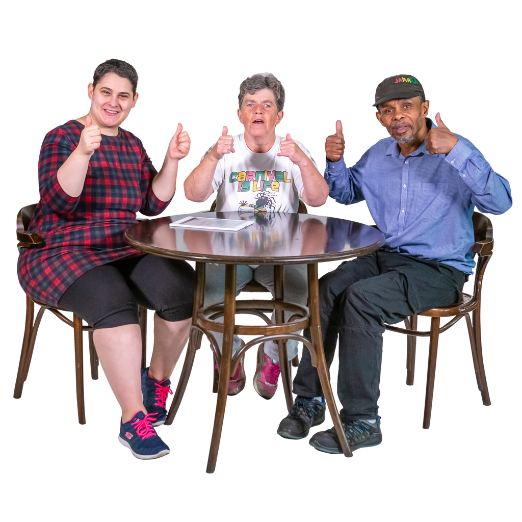 Three people sit a table giving a thumbs up sign. On the table is an Easy Read document that they are reviewing.