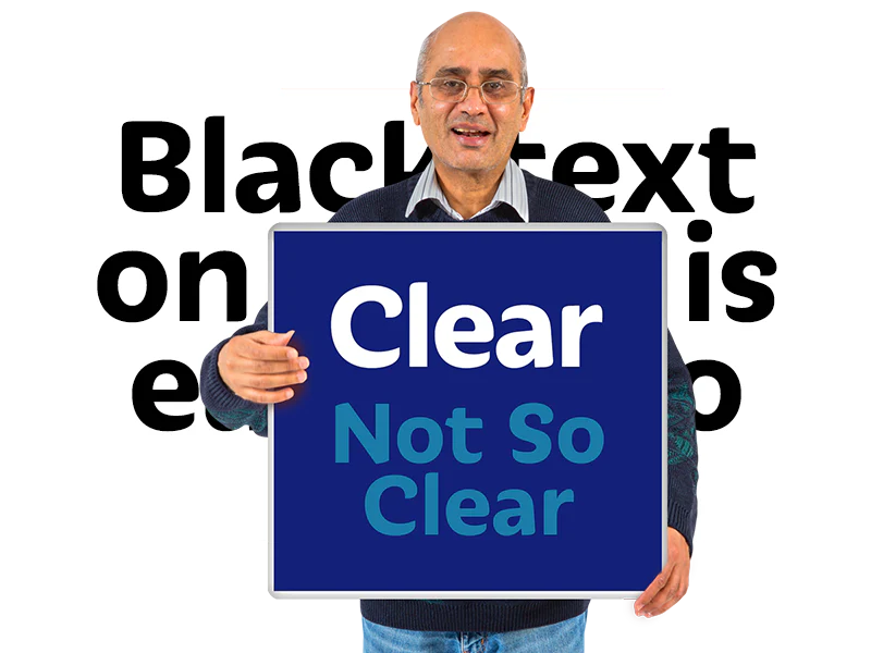 A man in a dark blue jumper holds a sign with white font on a dark background saying 'Clear' and with blue font on a darker blue background saying 'Not so clear' demonstrating differing contrast.